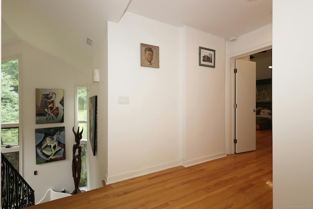 corridor featuring baseboards, visible vents, and light wood-style floors