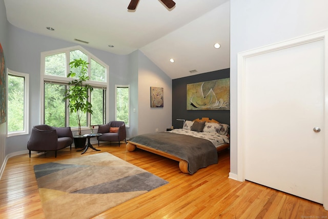 bedroom with a ceiling fan, visible vents, baseboards, and wood finished floors