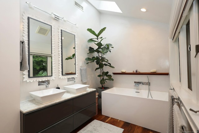 full bathroom with visible vents, wood finished floors, a sink, and a washtub