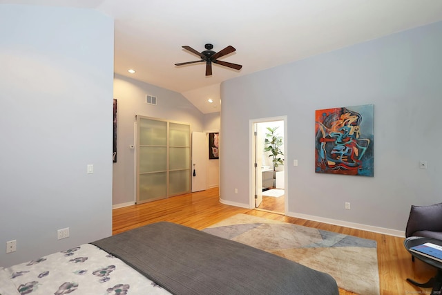 bedroom with light wood-style flooring, visible vents, vaulted ceiling, and baseboards