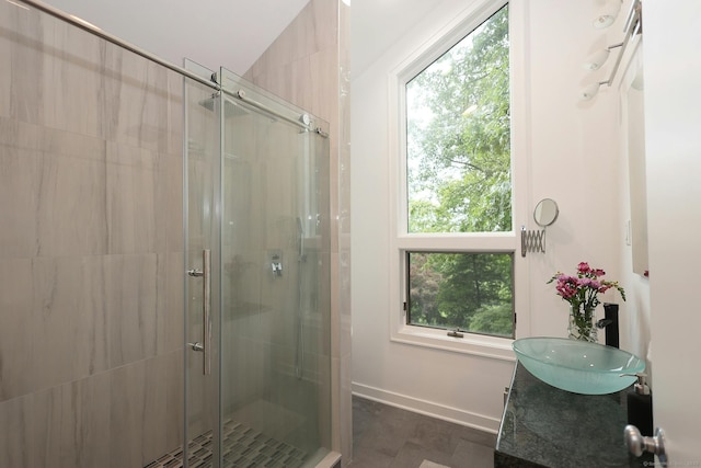 bathroom featuring a shower stall, baseboards, and vanity