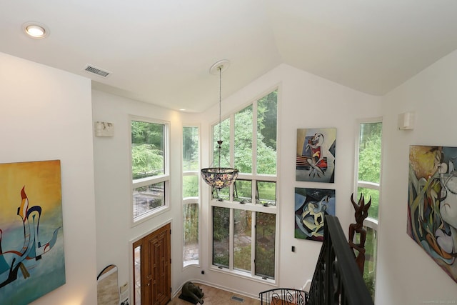 exercise area with lofted ceiling, a healthy amount of sunlight, and visible vents