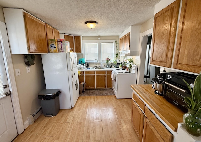 kitchen featuring white appliances, light countertops, a sink, and brown cabinetry