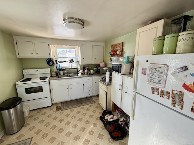 kitchen with light countertops, white appliances, white cabinetry, and a sink