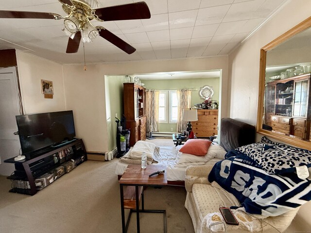 living area featuring ceiling fan, a baseboard heating unit, carpet floors, baseboard heating, and crown molding