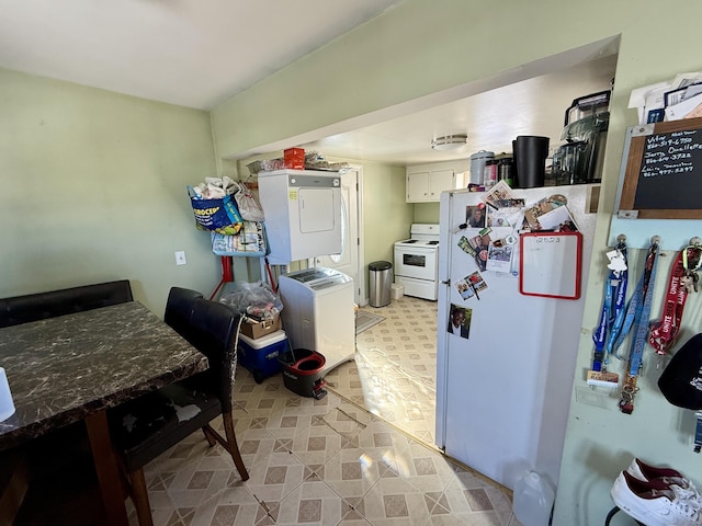 kitchen featuring stacked washer and dryer, dark countertops, white cabinetry, and light floors