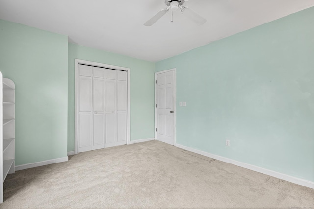 unfurnished bedroom featuring carpet floors, a ceiling fan, baseboards, and a closet