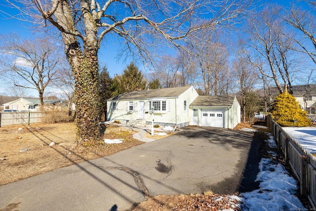 view of front of property with driveway, an attached garage, and fence