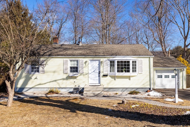 view of front of house featuring entry steps, driveway, a chimney, and an attached garage