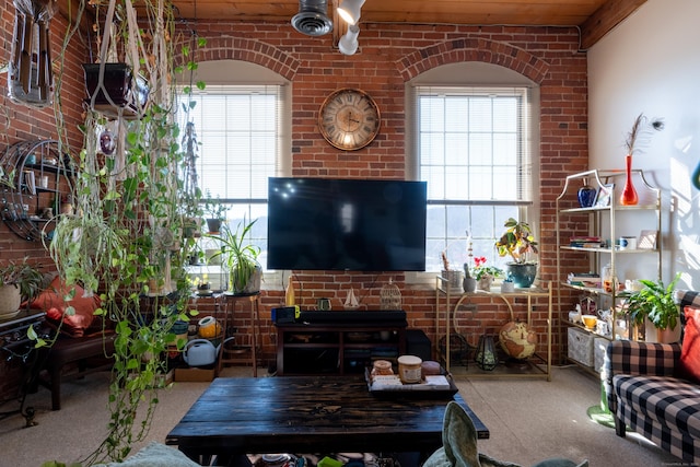 living room featuring a healthy amount of sunlight and brick wall