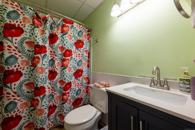 full bath featuring a drop ceiling, toilet, vanity, and a shower with curtain