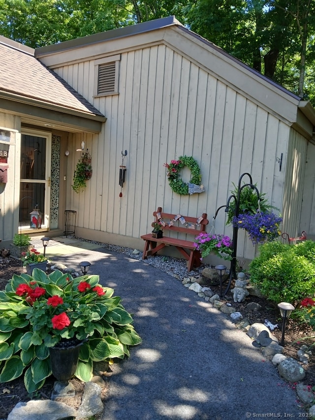 exterior space with a shingled roof and board and batten siding