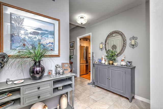 hallway with a textured ceiling and baseboards