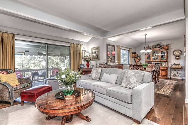 living room featuring lofted ceiling, hardwood / wood-style floors, and an inviting chandelier