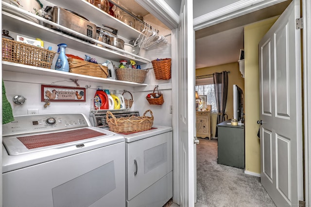 clothes washing area with washing machine and dryer, laundry area, and light colored carpet