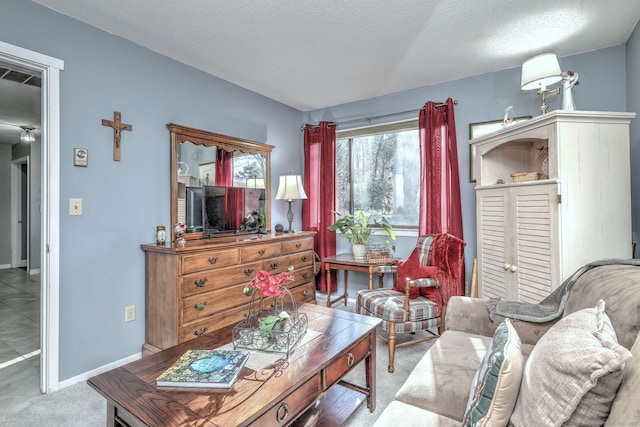 sitting room with carpet, visible vents, a textured ceiling, and baseboards