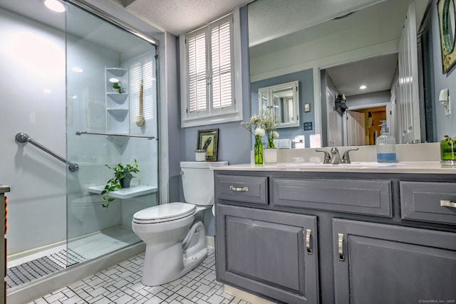 bathroom with toilet, a shower stall, and vanity