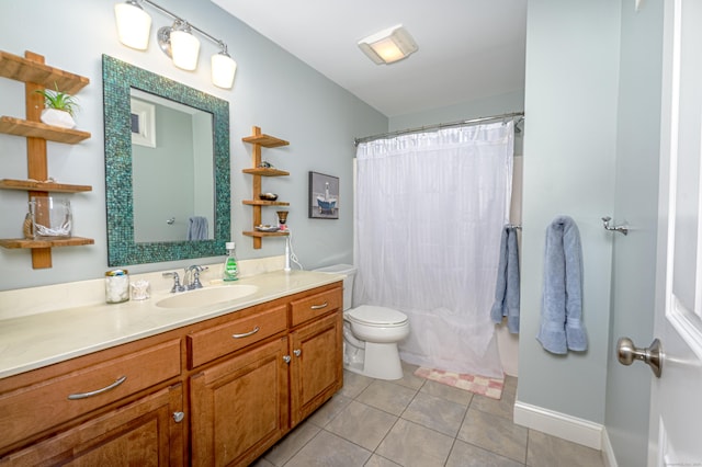 bathroom with tile patterned flooring, baseboards, vanity, and toilet