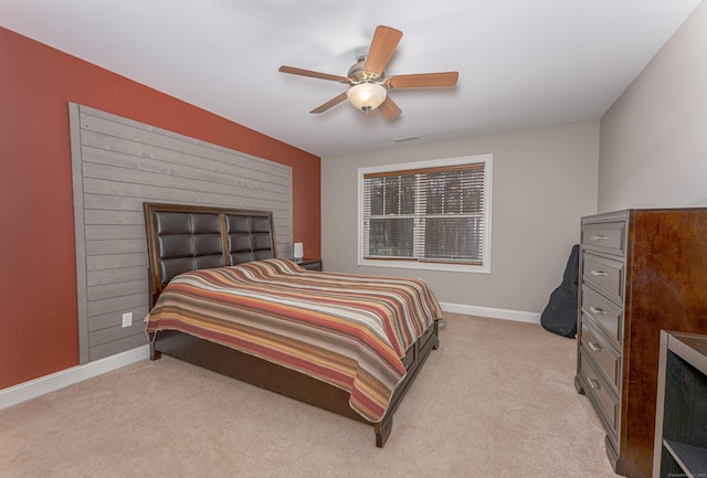 bedroom with a ceiling fan, light carpet, and baseboards