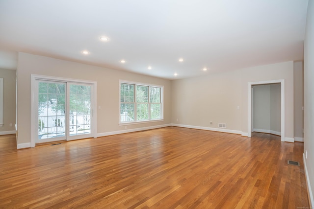 spare room with light wood-style floors, recessed lighting, visible vents, and baseboards