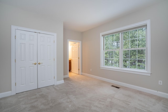 unfurnished bedroom featuring carpet floors, a closet, visible vents, and baseboards