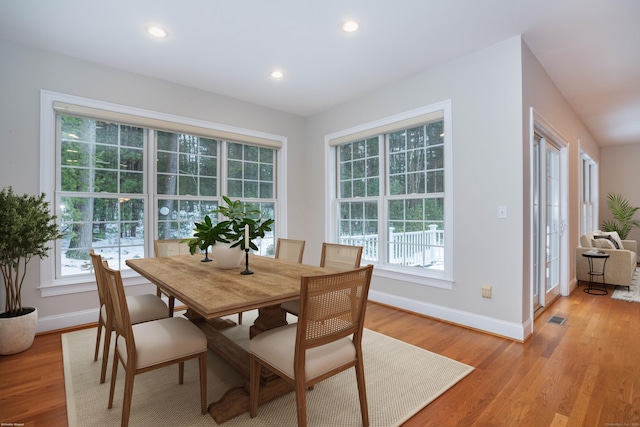 dining space featuring light wood-type flooring, a healthy amount of sunlight, baseboards, and recessed lighting