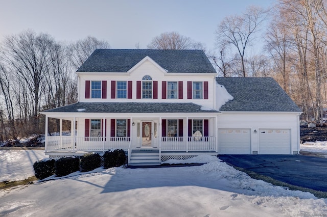 view of front facade featuring covered porch, aphalt driveway, roof with shingles, and a garage