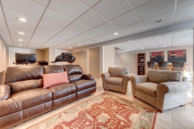 living room with a paneled ceiling, recessed lighting, stairs, and light tile patterned flooring