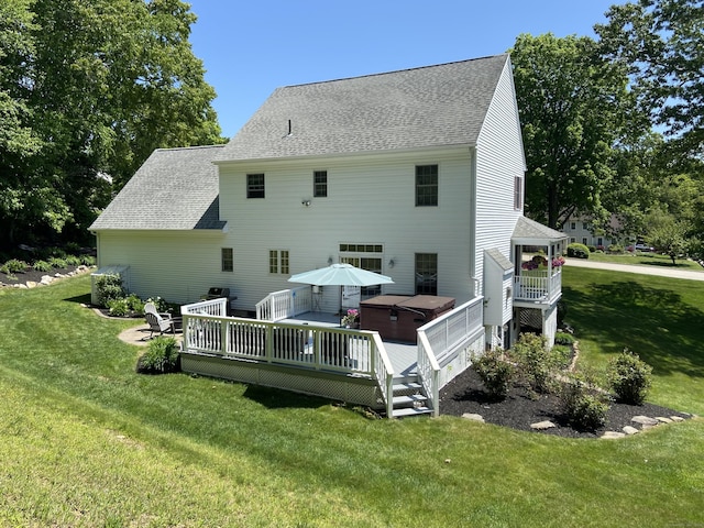 rear view of property featuring a shingled roof, a lawn, and a wooden deck