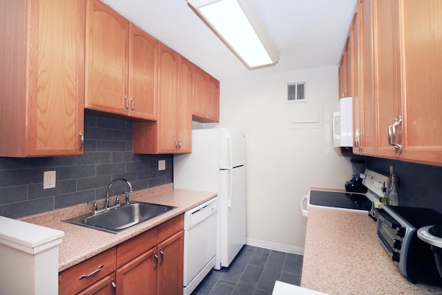 kitchen with light countertops, white appliances, visible vents, and a sink