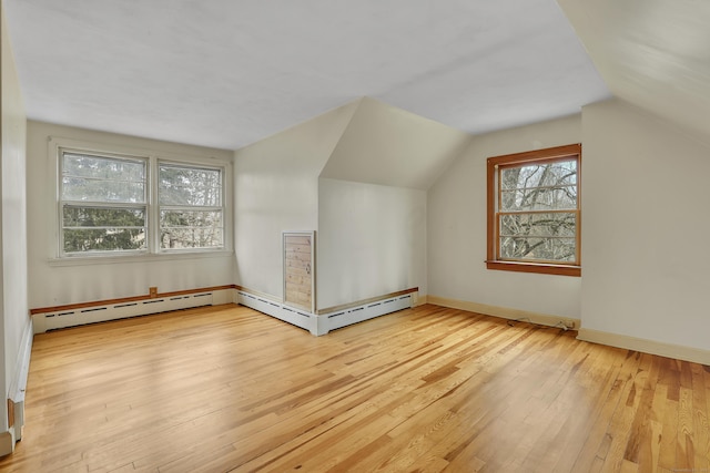 bonus room with a baseboard heating unit, baseboards, vaulted ceiling, and hardwood / wood-style floors