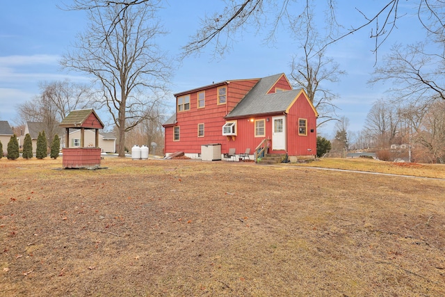 back of property featuring entry steps and roof with shingles