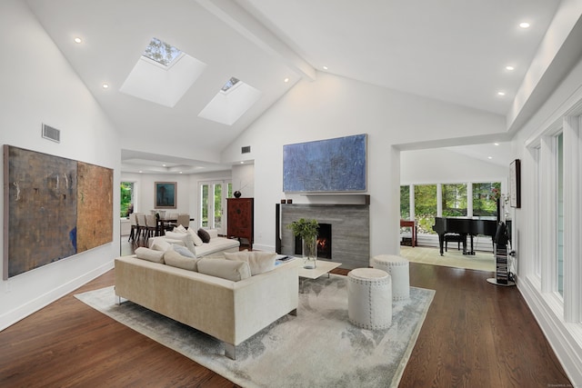 living room featuring a fireplace with flush hearth, dark wood-style flooring, visible vents, and high vaulted ceiling