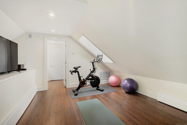 workout area with vaulted ceiling with skylight, baseboards, visible vents, and wood finished floors