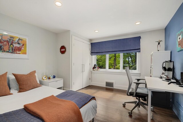 bedroom featuring baseboards, visible vents, wood finished floors, and recessed lighting