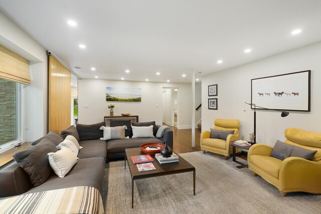 living room featuring light wood-type flooring, recessed lighting, and stairway