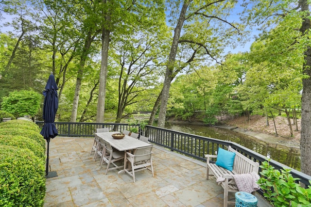 view of patio with outdoor dining area and a water view