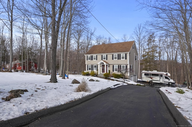 view of front facade with driveway and a chimney