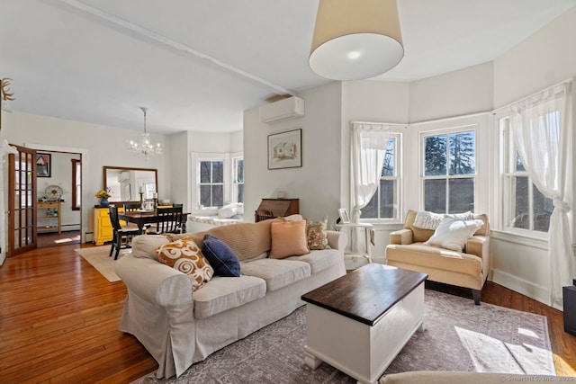 living room featuring a wealth of natural light, a wall unit AC, and hardwood / wood-style floors