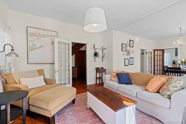 living room with a chandelier, wood finished floors, and french doors