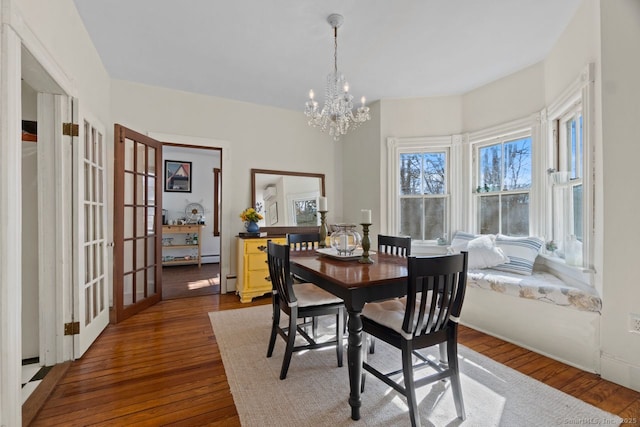 dining area featuring dark wood-style floors and a chandelier