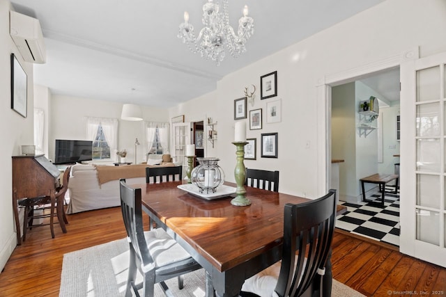 dining space featuring a wall mounted air conditioner, a notable chandelier, and wood finished floors