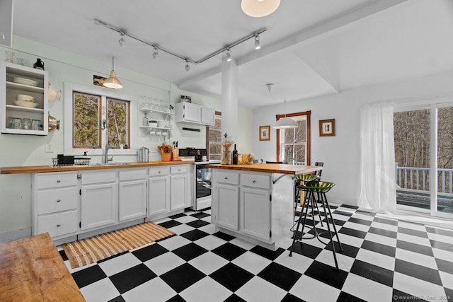 kitchen with open shelves, butcher block counters, range with electric stovetop, white cabinets, and light floors