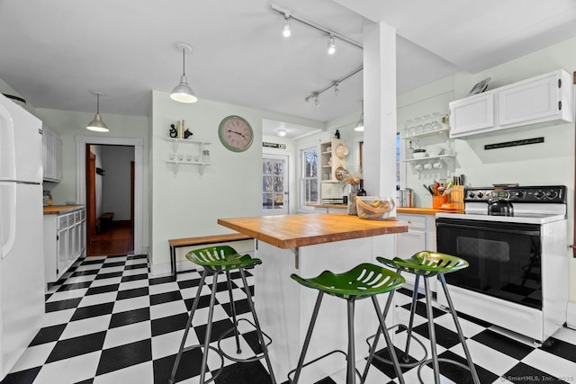 kitchen featuring dark floors, range with electric cooktop, wood counters, and freestanding refrigerator