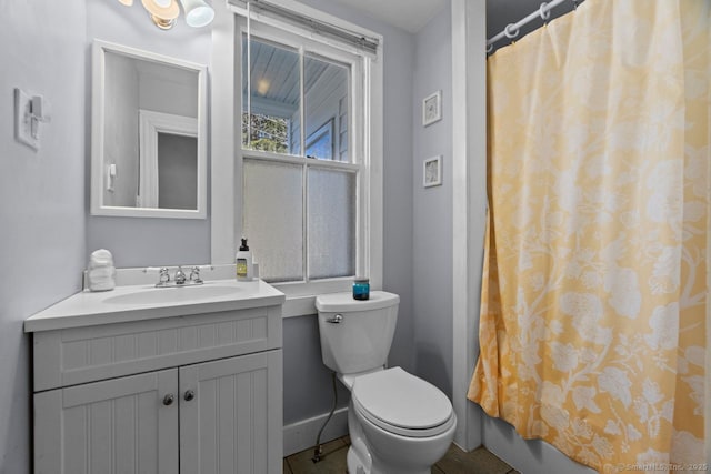 full bath featuring toilet, baseboards, and vanity