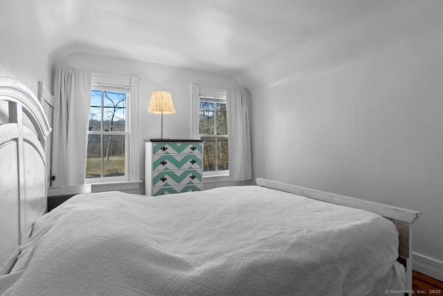 bedroom with vaulted ceiling and wood finished floors