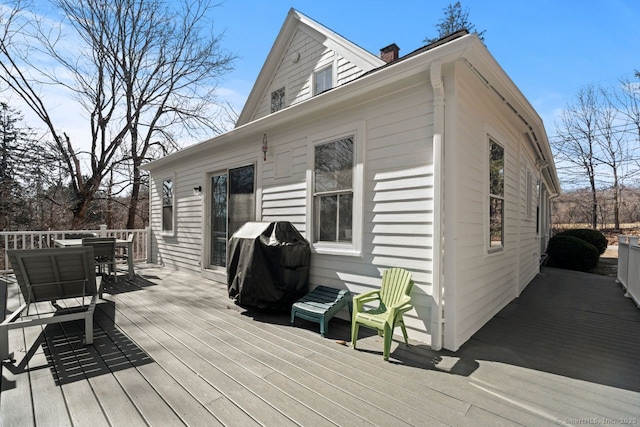 wooden terrace featuring outdoor dining area and grilling area