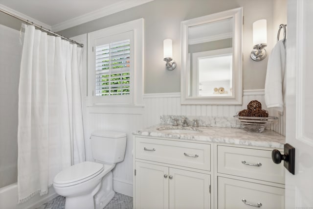 bathroom featuring toilet, a wainscoted wall, vanity, shower / bath combo with shower curtain, and crown molding