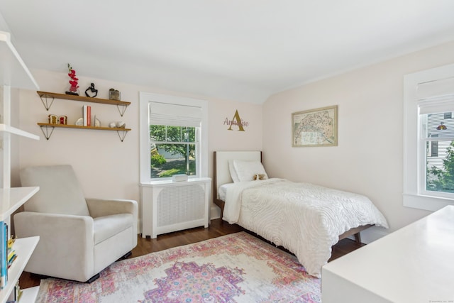 bedroom with multiple windows, vaulted ceiling, and wood finished floors