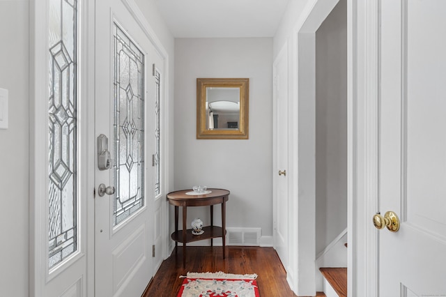 foyer entrance with stairway, baseboards, visible vents, and dark wood-type flooring